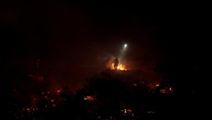 A firefighter works at the site of a wildfire, named the Lilac Fire, in the Bonsall area of San Diego County, California, U.S.,  January 21, 2025.  REUTERS/Mike Blake