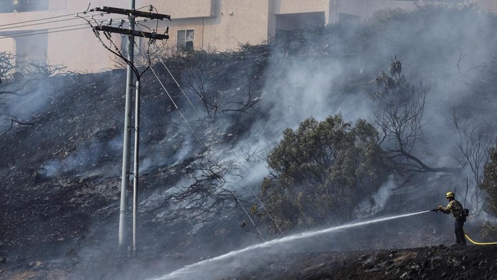 Firefighters tackle the Friars Fire, a blaze that broke out near the Fashion Valley Mall in San Diego, California, U.S. January 21, 2025. REUTERS/Mike Blake