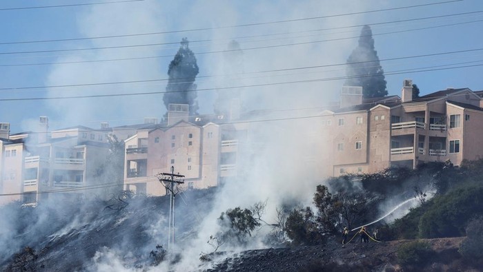 Firefighters tackle the Friars Fire, a blaze that broke out near the Fashion Valley Mall in San Diego, California, U.S. January 21, 2025. REUTERS/Mike Blake