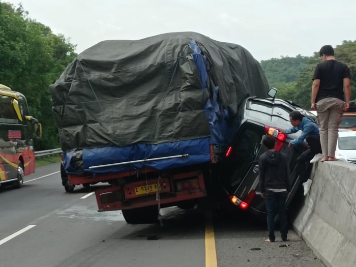 Kecelakaan di Km 80 Tol Cipularang mengakibatkan mobil Avanza terjepit di antara truk dengan pembatas jalan.