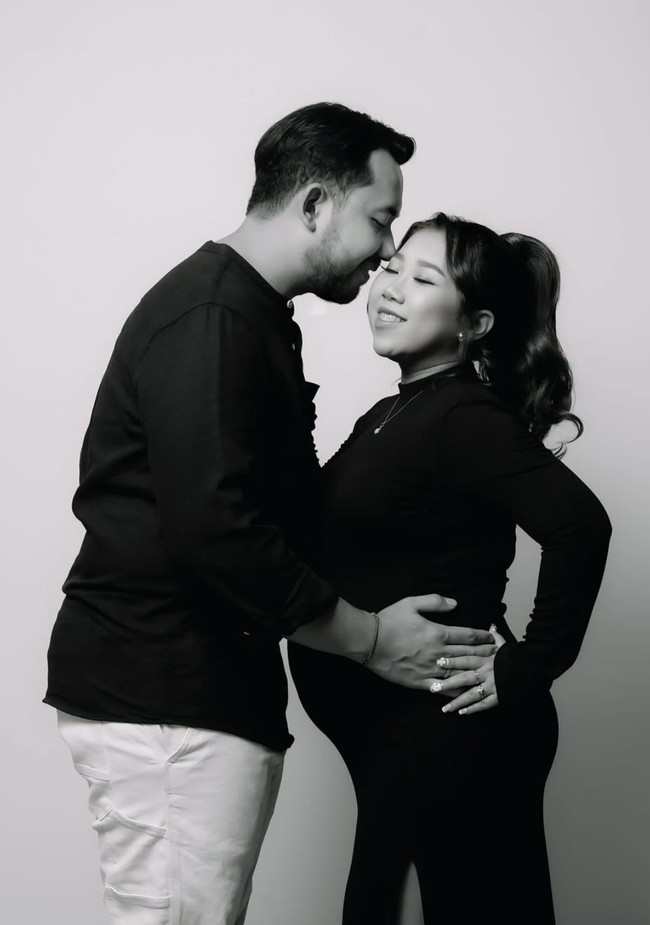 Kiky tampil mengenakan dress hitam panjang bermodel kerah semi turtle neck. Dress tersebut memiliki slit atau potongan yang cukup tinggi sampai ke paha. Sementara suaminya memilih kaos lengan panjang berwarna hitam dipadukan dengan celana panjang putih. Foto: Instagram/@kikysaputrii