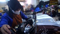 Pekerja menjahit kain sarung di Industri kain sarung Asaputex, Tegal, Jawa Tengah, Rabu (22/1/2025).