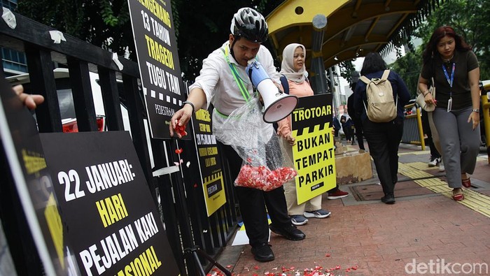 Aktivis dari Koalisi Pejalan Kaki melakukan aksi tabur bunga dan membagikan bunga di kawasan Tugu Tani, Jakarta, Rabu (22/1/2025). Aksi tersebut untuk memperingati Hari Pejalan Kaki Nasional serta untuk mengenang sembilan pejalan kaki yang meninggal akibat tertabrak mobil di lokasi tersebut, 13 tahun lalu.