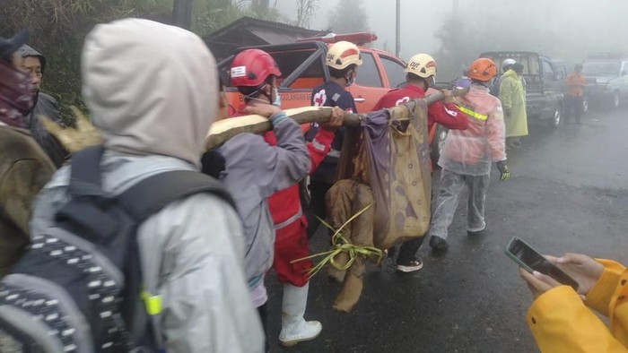 In this undated photo released by Indonesia's National Disaster Management Agency (BNPB) on Wednesday, Jan. 22, 2025, rescuers carry the body of a victim of flash flood which triggered a landslide, in Pekalongan, Central Java, Indonesia. (BNPB via AP)