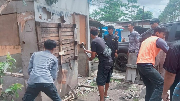 Polisi dan warga saat bongkar kios yang dijadikan tempat transaksi obat-obatan keras