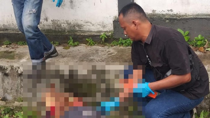 Polisi saat mengevakuasi mayat pria yang ditemukan di pinggir jalan di Kota Jambi