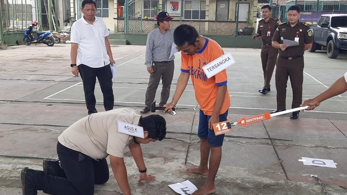 Tersangka, Yusak memperagakan adegan pembunuhan keluarga kakaknya di Ngancar, Kabupaten Kediri