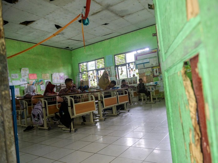 Sekolah terdampak tol Serang-Panimbang di Kabupaten Serang Siswa mengikuti kegiatan belajar di SD Negeri Inpres Cikeusal, Kabupaten Serang, Banten, Rabu (22/1/2025). Menurut pihak sekolah, sebanyak empat ruang kelas mengalami kerusakan akibat terdampak jalan tol Serang-Panimbang dan hingga kini masih menunggu relokasi yang dijanjikan Pejabat Pembuatan Komitmen (PPK) Tol Serang-Panimbang. ANTARA FOTO/Muhammad Bagus Khoirunas/agr