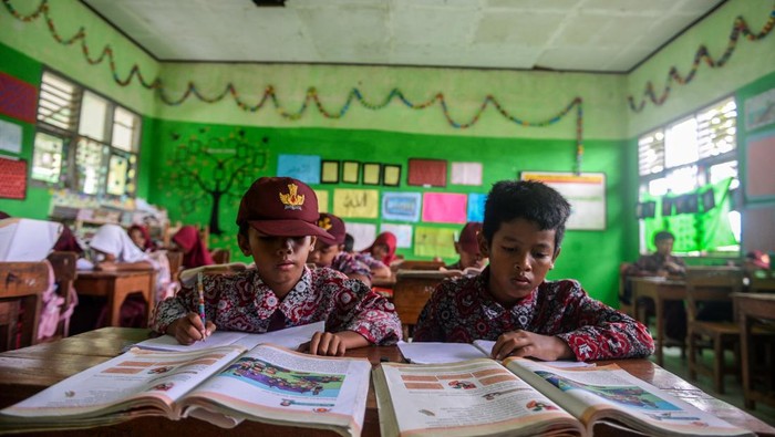 Siswa mengikuti kegiatan belajar di SD Negeri Inpres Cikeusal, Kabupaten Serang, Banten, Rabu (22/1/2025). Menurut pihak sekolah, sebanyak empat ruang kelas mengalami kerusakan akibat terdampak jalan tol Serang-Panimbang dan hingga kini masih menunggu relokasi yang dijanjikan Pejabat Pembuatan Komitmen (PPK) Tol Serang-Panimbang. ANTARA FOTO/Muhammad Bagus Khoirunas/agr