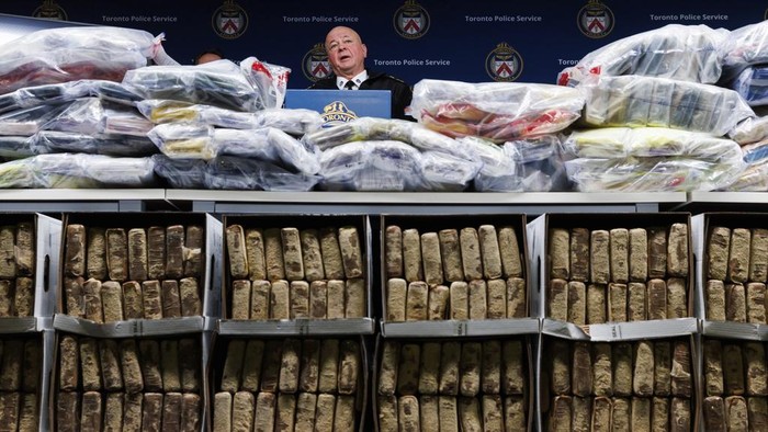 Toronto Police Chief Myron Demkiw, center, speaks to media behind a wall of seized drugs during a press conference announcing the seizure of 835 kg., about 1,840 lbs. of cocaine, Tuesday, Jan. 21, 2025, in Toronto. (Cole Burston/The Canadian Press via AP)