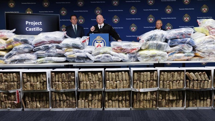 Toronto Police Chief Myron Demkiw, center, speaks to media behind a wall of seized drugs during a press conference announcing the seizure of 835 kg., about 1,840 lbs. of cocaine, Tuesday, Jan. 21, 2025, in Toronto. (Cole Burston/The Canadian Press via AP)