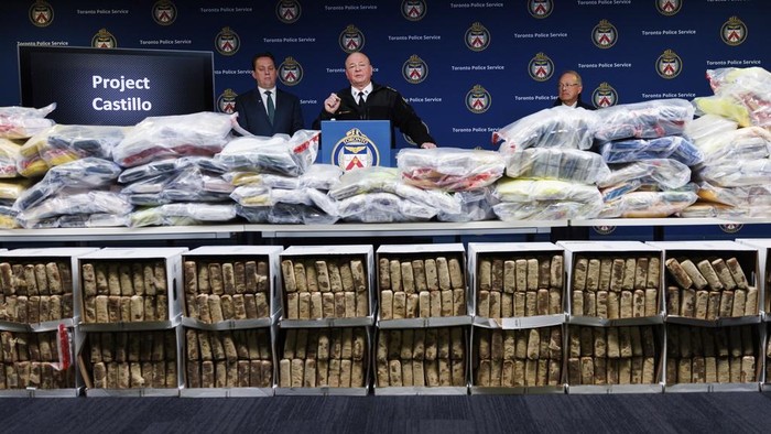 Terungkap Penyitaan Kokain Terbesar dalam Sejarah Kanada Toronto Police Chief Myron Demkiw, center, speaks to media behind a wall of seized drugs during a press conference announcing the seizure of 835 kg., about 1,840 lbs. of cocaine, Tuesday, Jan. 21, 2025, in Toronto. (Cole Burston/The Canadian Press via AP)