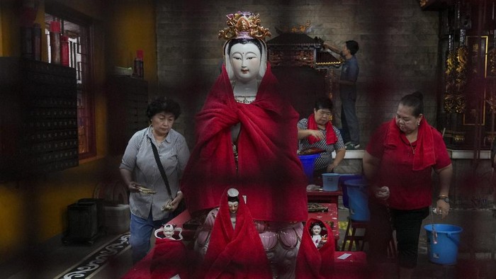 People arrange statues of Chinese gods in preparation for the Lunar New Year celebration at Amurva Bhumi Temple in Jakarta, Indonesia, Wednesday, Jan. 22, 2025. (AP Photo/Tatan Syuflana)
