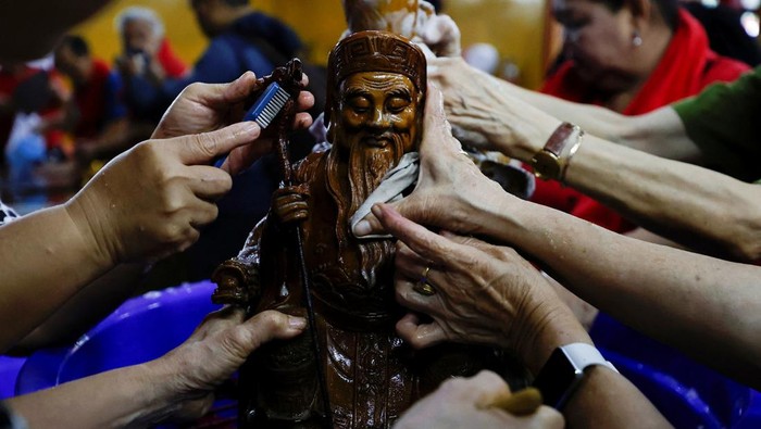 A worshiper cleans a sacred figure during a preparation for the Lunar New Year celebrations, at Amurva Bhumi temple, in Jakarta, Indonesia, January 22, 2025. REUTERS/Willy Kurniawan     TPX IMAGES OF THE DAY