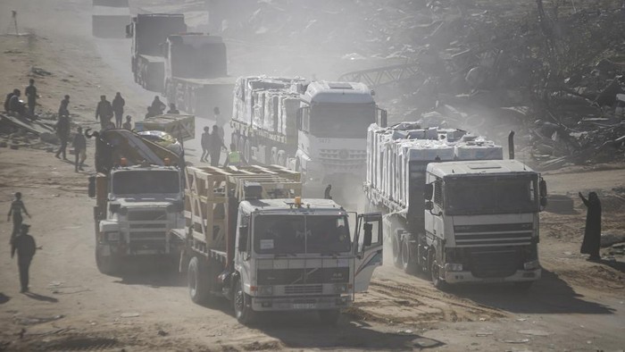 Humanitarian aid trucks enter through the Kerem Shalom crossing from Egypt into the Gaza Strip, as a ceasefire deal between Israel and Hamas went into effect, in Rafah, Tuesday, Jan. 21, 2025. (AP Photo/Jehad Alshrafi)