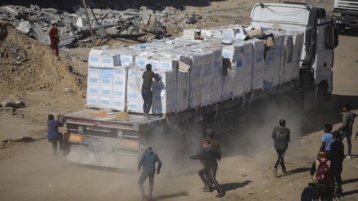 Humanitarian aid trucks enter through the Kerem Shalom crossing from Egypt into the Gaza Strip, as a ceasefire deal between Israel and Hamas went into effect, in Rafah, Tuesday, Jan. 21, 2025. (AP Photo/Jehad Alshrafi)