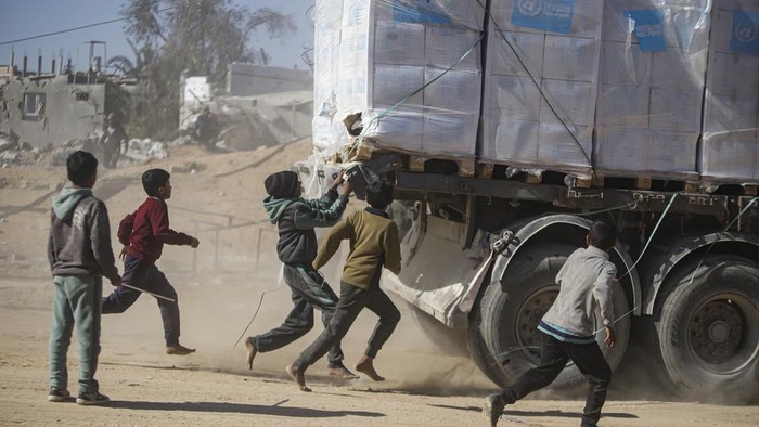Humanitarian aid trucks enter through the Kerem Shalom crossing from Egypt into the Gaza Strip, as a ceasefire deal between Israel and Hamas went into effect, in Rafah, Tuesday, Jan. 21, 2025. (AP Photo/Jehad Alshrafi)