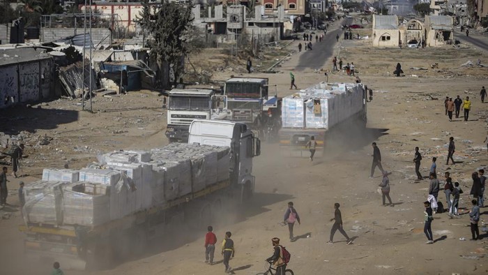 Humanitarian aid trucks enter through the Kerem Shalom crossing from Egypt into the Gaza Strip, as a ceasefire deal between Israel and Hamas went into effect, in Rafah, Tuesday, Jan. 21, 2025. (AP Photo/Jehad Alshrafi)