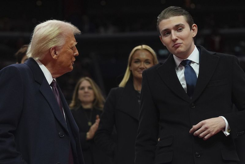 President Donald Trump talks with his son Barron Trump as they attend an indoor Presidential Inauguration parade event at Capital One Arena, Monday, Jan. 20, 2025, in Washington. (AP Photo/Evan Vucci)