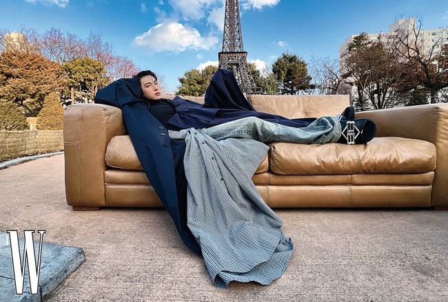 Semakin nyentrik. Ada pula foto yang menampilkan Im Siwan seolah berbaring di atas sofa yang diletakkan di depan Eiffel Tower di Paris. Kali ini memakai maxi coat berwarna biru dan layered pants Balenciaga. Foto: dok. W Korea