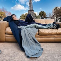 Semakin nyentrik. Ada pula foto yang menampilkan Im Siwan seolah berbaring di atas sofa yang diletakkan di depan Eiffel Tower di Paris. Kali ini memakai maxi coat berwarna biru dan layered pants Balenciaga. Foto: dok. W Korea