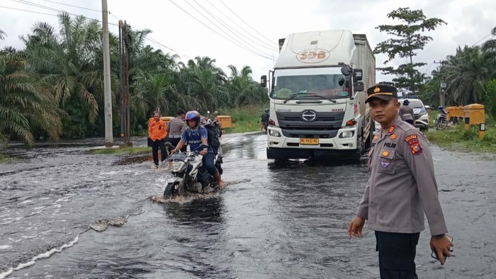 Kapolsek Pangkalan Kerinci AKP Tatit Riskyan Hanfi saat memandu kendaraan melintas. (Dok Polsek Pangkalan Kerinci)
