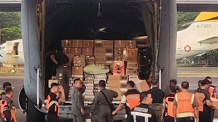 Petugas menurunkan muatan 10.000 susu dan masker dari pesawat Hercules C-130 milik TNI AU, di Flores Timur, Nusa Tenggara Timur (NTT).