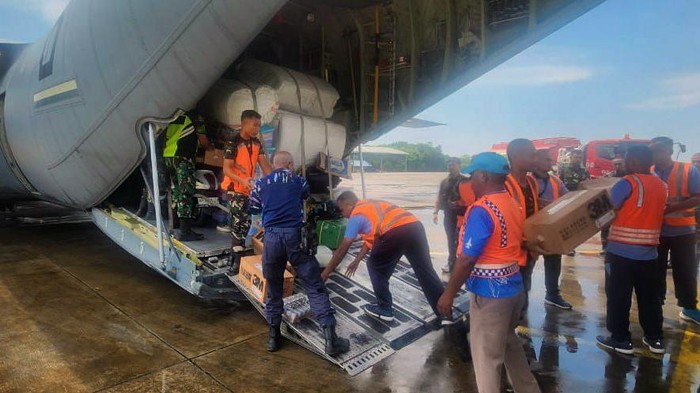 Petugas menurunkan muatan 10.000 susu dan masker dari pesawat Hercules C-130 milik TNI AU, di Flores Timur, Nusa Tenggara Timur (NTT).