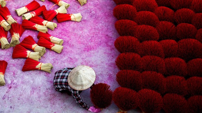 Workers arrange incense sticks to be dried, in a courtyard ahead of the Lunar New Year celebrations in Quang Phu Cau village, outside Hanoi, Vietnam, January 20, 2025. REUTERS/Athit Perawongmetha