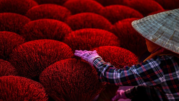 Workers arrange incense sticks to be dried, in a courtyard ahead of the Lunar New Year celebrations in Quang Phu Cau village, outside Hanoi, Vietnam, January 20, 2025. REUTERS/Athit Perawongmetha