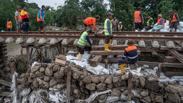 Pekerja memperbaiki jalur kereta api (KA) km 32+5/7 akibat amblas tergerus banjir luapan air Sungai Tuntang di Gubug, Kabupaten Grobogan, Jawa Tengah, Rabu (22/1/2025). PT Kereta Api Indonesia (Persero) Daop 4 Semarang terus melakukan perbaikan dengan pengerahan puluhan pekerja dan alat berat guna mempercepat perbaikan dan sejumlah perjalanan KA yang terganggu masih dilakukan rekayasa pola operasi berupa pengalihan rute perjalanan KA. ANTARA FOTO/Aji Styawan/agr