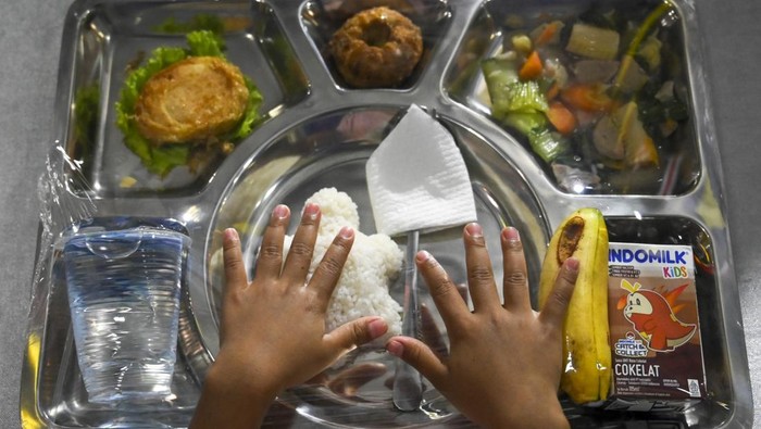 Sejumlah siswa melintas di dekat Kapal Perang Republik Indonesia (KRI) Banda Aceh 593 usai mengikuti program Makan Bergizi Gratis (MBG) di Dermaga Komando Lintas Laut Militer (Kolinlamil), Jakarta Utara, Kamis (23/1/2025). Program MBG tersebut diikuti 270 siswa SD dan PAUD dengan sajian menu nasi, sayur, tahu, telur, pisang, dan susu yang diolah dari hasil pemanfaatan lahan dalam program Ketahanan Pangan Kolinlamil. ANTARA FOTO/Muhammad Ramdan/YU