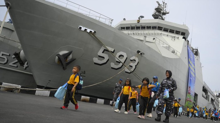 Potret Makan Bergizi Gratis di Kapal Perang RI Sejumlah siswa melintas di dekat Kapal Perang Republik Indonesia (KRI) Banda Aceh 593 usai mengikuti program Makan Bergizi Gratis (MBG) di Dermaga Komando Lintas Laut Militer (Kolinlamil), Jakarta Utara, Kamis (23/1/2025). Program MBG tersebut diikuti 270 siswa SD dan PAUD dengan sajian menu nasi, sayur, tahu, telur, pisang, dan susu yang diolah dari hasil pemanfaatan lahan dalam program Ketahanan Pangan Kolinlamil. ANTARA FOTO/Muhammad Ramdan/YU