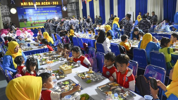 Sejumlah siswa melintas di dekat Kapal Perang Republik Indonesia (KRI) Banda Aceh 593 usai mengikuti program Makan Bergizi Gratis (MBG) di Dermaga Komando Lintas Laut Militer (Kolinlamil), Jakarta Utara, Kamis (23/1/2025). Program MBG tersebut diikuti 270 siswa SD dan PAUD dengan sajian menu nasi, sayur, tahu, telur, pisang, dan susu yang diolah dari hasil pemanfaatan lahan dalam program Ketahanan Pangan Kolinlamil. ANTARA FOTO/Muhammad Ramdan/YU