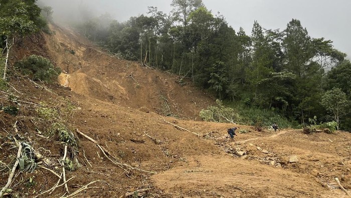 The wreckage of a car is stuck in the mud at an area affected by a landslide following a flash flood in Pekalongan, Central Java, Indonesia, Wednesday, Jan. 22, 2025. (AP Photo/Janaki DM)