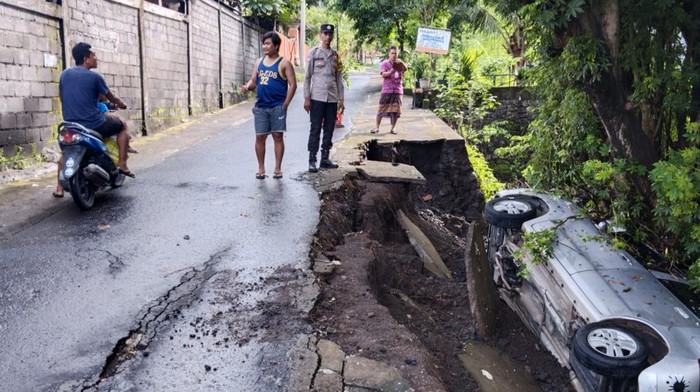 Sebuah mobil terperosok ke jurang saat parkir di pinggir jalan di depan SMKN 1 Kubu, Karangasem, Bali, pada Kamis (23/1/2025). (Foto: Dok. Polres Karangasem)