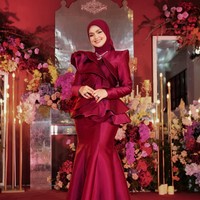 Sesuai dengan tema dekorasinya, Siti tampil cantik kenakan dress berwarna merah marun. Dress tersebut memiliki model duyung pada bagian bawah dan ruffle pada bahu hingga pinggangnya. Foto: Instagram/@ctdk