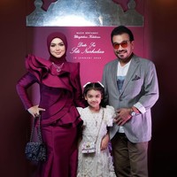 Anak pertama Siti Nurhaliza, Siti Aafiyah, juga tampak hadir dan berpose bersama kedua orangtuanya. Sang putri tampil mengenakan dress berwarna putih dipadukan dengan sepasang sepatu berwarna keemasan. Foto: Instagram/@ctdk