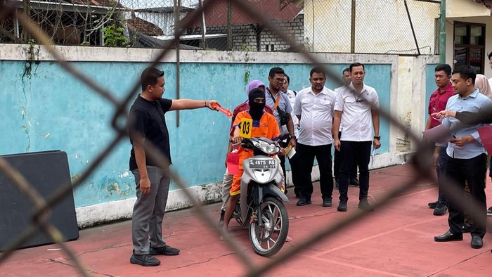 Tersangka AI saat rekonstruksi pembunuhan temannya di Lamongan