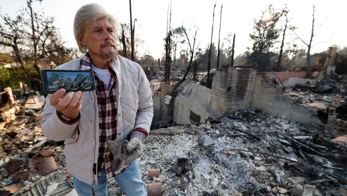 Hilda Dawley and her husband, Greg Dawley, carry belongings they found after their home burned in the Eaton Fire, in Altadena, California, U.S. January 19, 2025. REUTERS/Fred Greaves