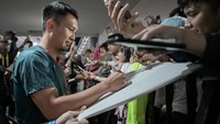 Pebulutangkis ganda putra Indonesia Mohammad Ahsan menandatangani kaos penggemar seusai laga terakhirnya pada turnamen Daihatsu Indonesia Masters 2025 di Istora Senayan, Jakarta, Kamis (23/1/2025). 