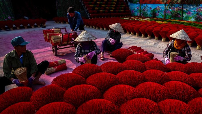 Workers arrange incense sticks to be dried, in a courtyard ahead of the Lunar New Year celebrations in Quang Phu Cau village, outside Hanoi, Vietnam, January 20, 2025. REUTERS/Athit Perawongmetha