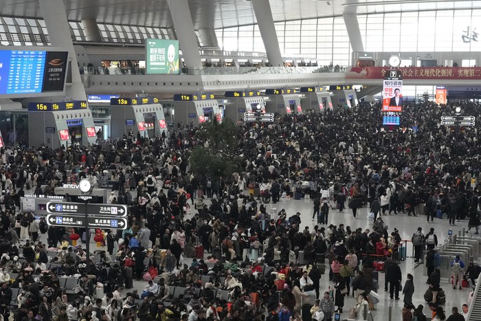 Passengers wait to ride trains as crowds begin to swell ahead of the Chinese Lunar New Year at a railway station in Hangzhou, China on Saturday, Jan. 18, 2025. (AP Photo/Aaron Favila)