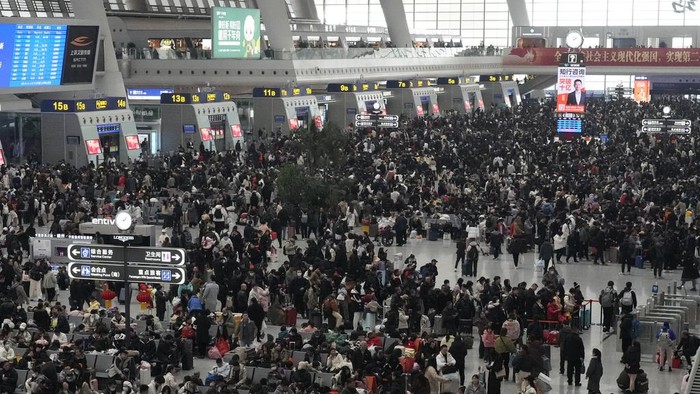 Passengers wait to ride trains as crowds begin to swell ahead of the Chinese Lunar New Year at a railway station in Hangzhou, China on Saturday, Jan. 18, 2025. (AP Photo/Aaron Favila)
