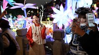 Beberapa pengunjung bahkan mengenakan pakaian tradisional atau cosplay dan berfoto di taman lampion.