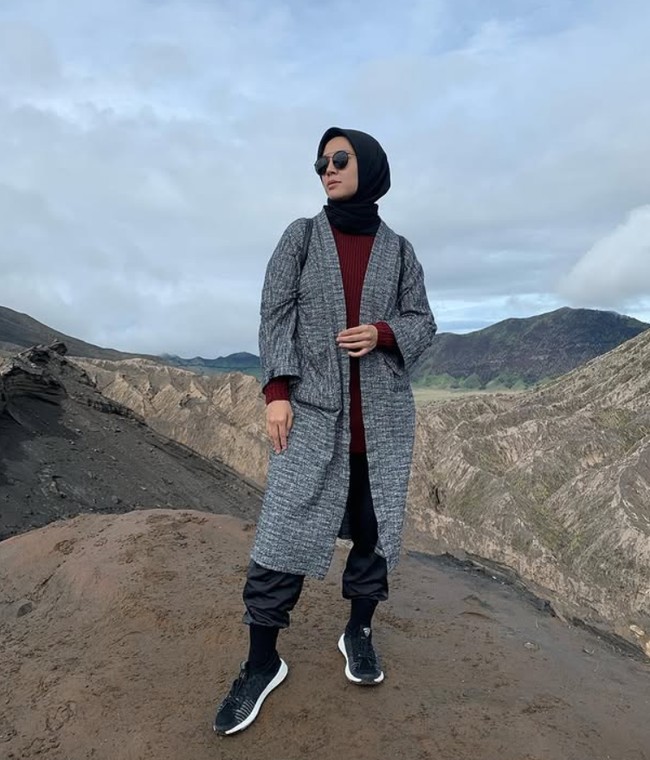 Wanita kelahiran 17 Maret 1988 ini sering mengunggah foto OOTD saat liburan. Seperti dalam foto ini, Ratna Galih memadukan hijab segi empat hitam dipadu dengan inner rajut warna merah marun dan ia padukan dengan outer abu-abu tua, saat pergi ke Taman Nasional Bromo Tengger Semeru, Jawa Timur. Foto: Dok. Instagram @ratnagalih.