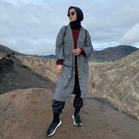 Wanita kelahiran 17 Maret 1988 ini sering mengunggah foto OOTD saat liburan. Seperti dalam foto ini, Ratna Galih memadukan hijab segi empat hitam dipadu dengan inner rajut warna merah marun dan ia padukan dengan outer abu-abu tua, saat pergi ke Taman Nasional Bromo Tengger Semeru, Jawa Timur. Foto: Dok. Instagram @ratnagalih.