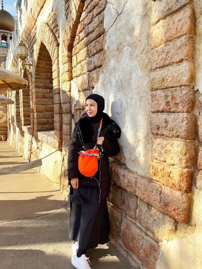 Ketika liburan ke Jepang, pemain sejumlah judul FTV ini kembali tampil serba monokrom. Ratna Galih menggunakan hijab pashmina, jaket dan busana serba hitam. Agar tak monoton, Ratna Galih memilih bucket bag warna merah. Foto: Dok. Instagram @ratnagalih.
