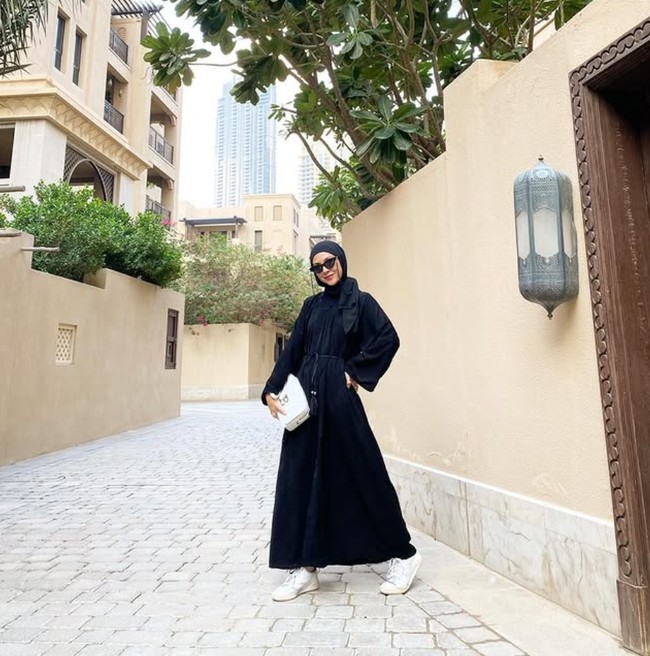Saat berada di Dubai, model video klip Bunga Citra Lestari berjudul Cinta Pertama ini tampil simpel dengan memakai dress dan hijab hitam, ia padukan dengan tas dan sneakers putih. Ratna Galih menambahkan aksesori kacamata hitam untuk melengkapi penampilannya. Foto: Dok. Instagram @ratnagalih.