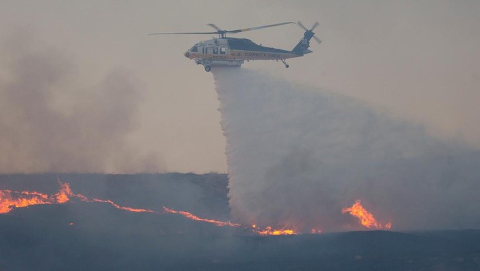 Kebakaran California Belum Usai, Kobaran Api Melanda Wilayah Baru Members of a firefighting crew work to battle the Hughes Fire near Castaic Lake, north of Santa Clarita, California, U.S. January 22, 2025. REUTERS/Ringo Chiu